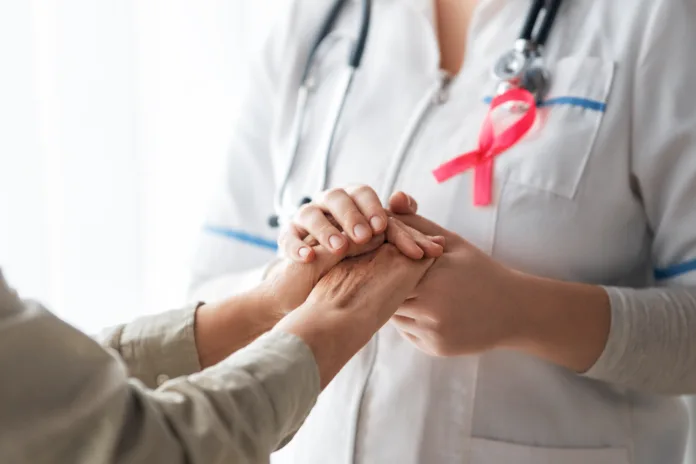 pink-ribbon-for-breast-cancer-awareness-female-patient-listening-to-doctor-in-medical-office-support-people-living-with-tumor-illness-stockpack-istock Pink ribbon for breast cancer awareness. Female patient listening to doctor in medical office. Support people living with tumor illness.